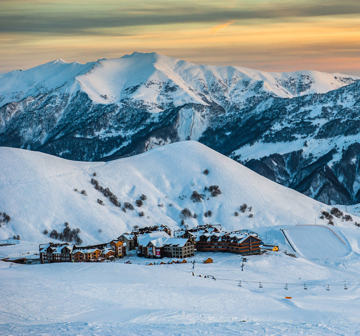 snowy winter mountains in sun day. georgia, from ski resort guda